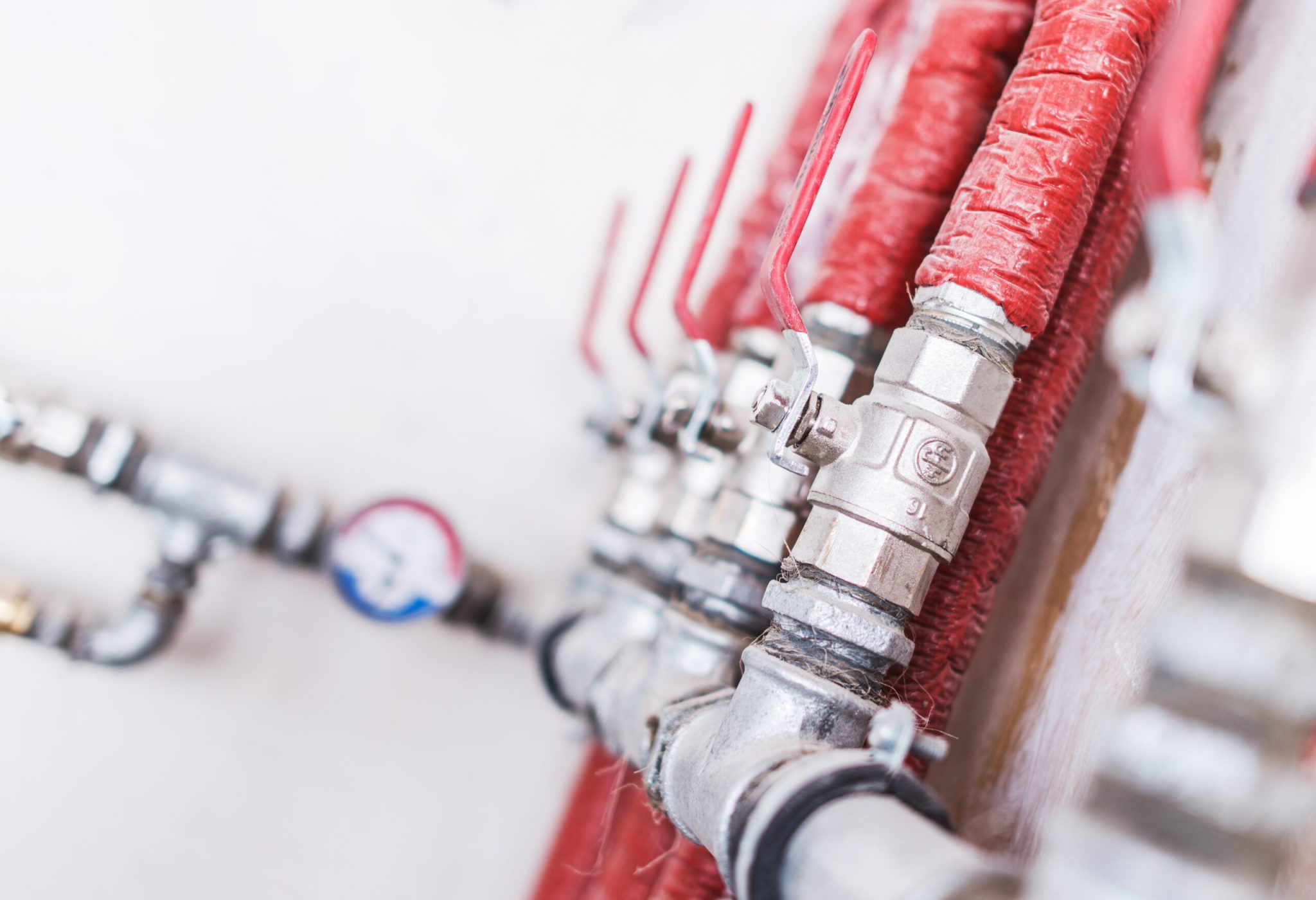 Home Plumbing System Closeup Photo. Red Isolated Pipes with Ball Valves. Residential Water Supply System.